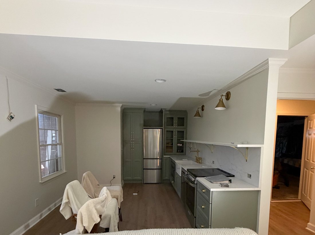 Kitchen and living area prepped with covered furniture