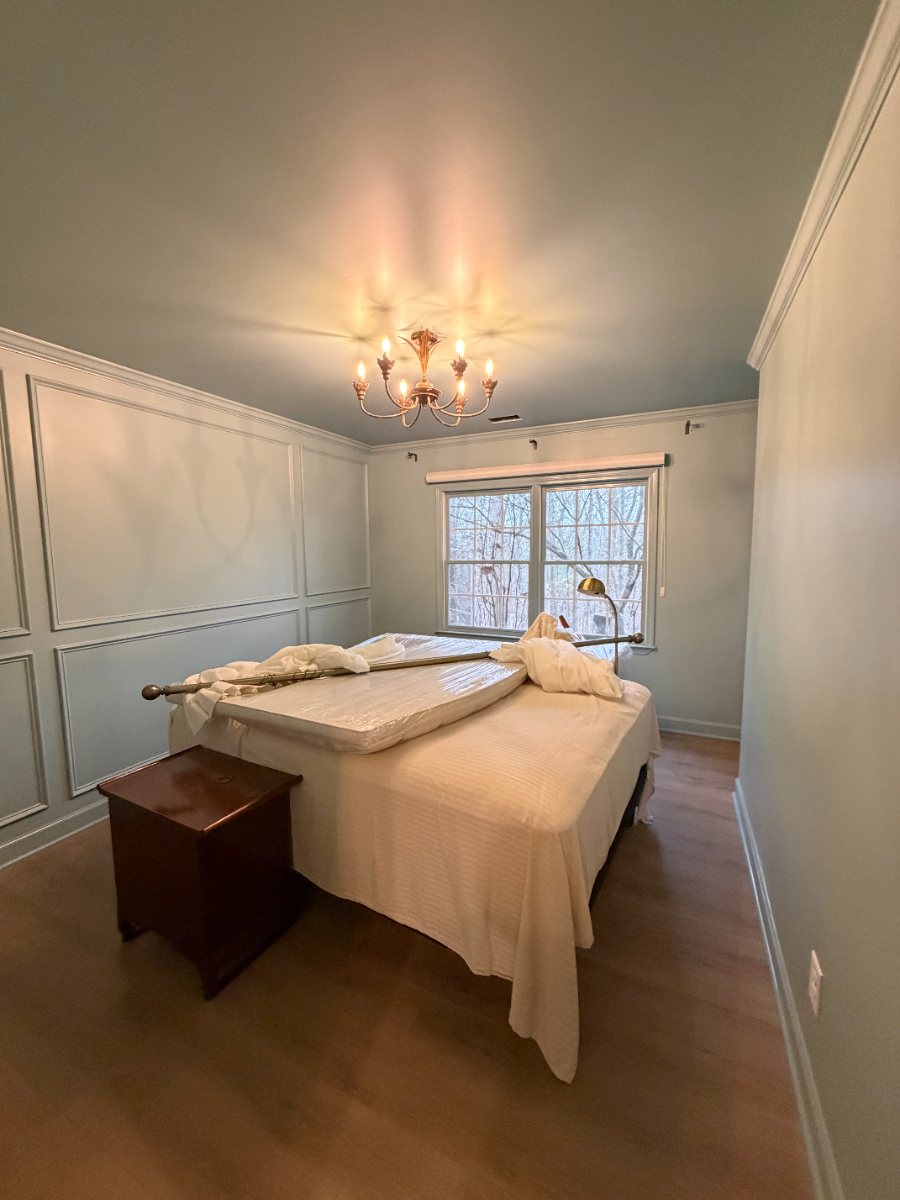 Bedroom with fresh wall paneling and soft green walls